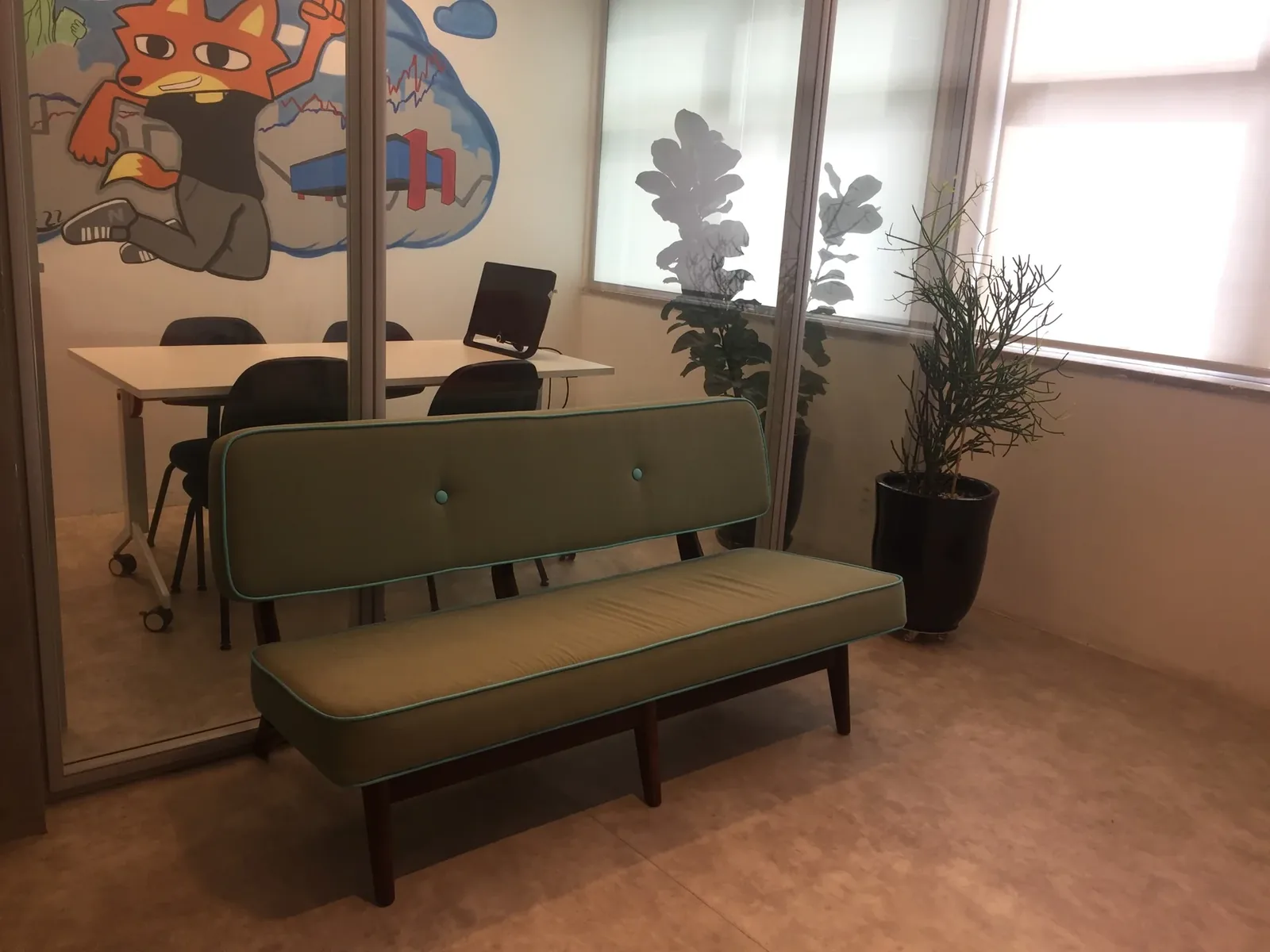 Área de convivência da SP Locus com poltronas e mesas de apoio