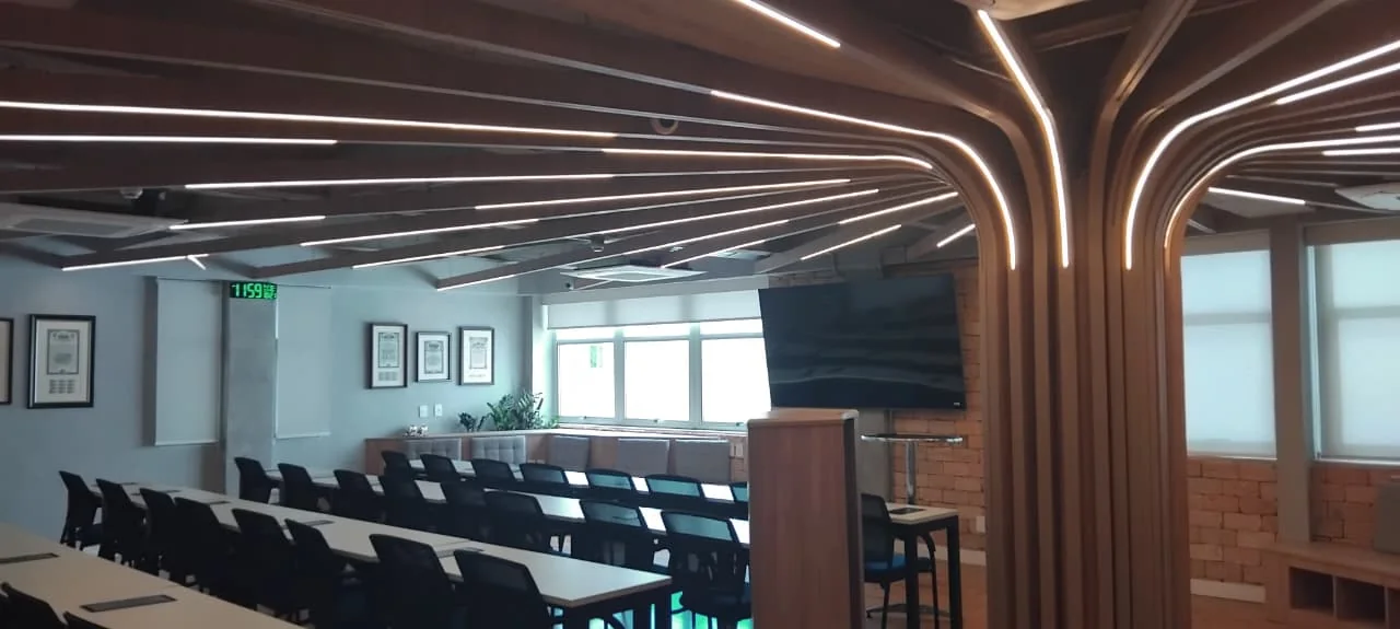 Auditório do 5º andar da SP Locus com arquitetura de madeira em arcos e cadeiras posicionadas para evento