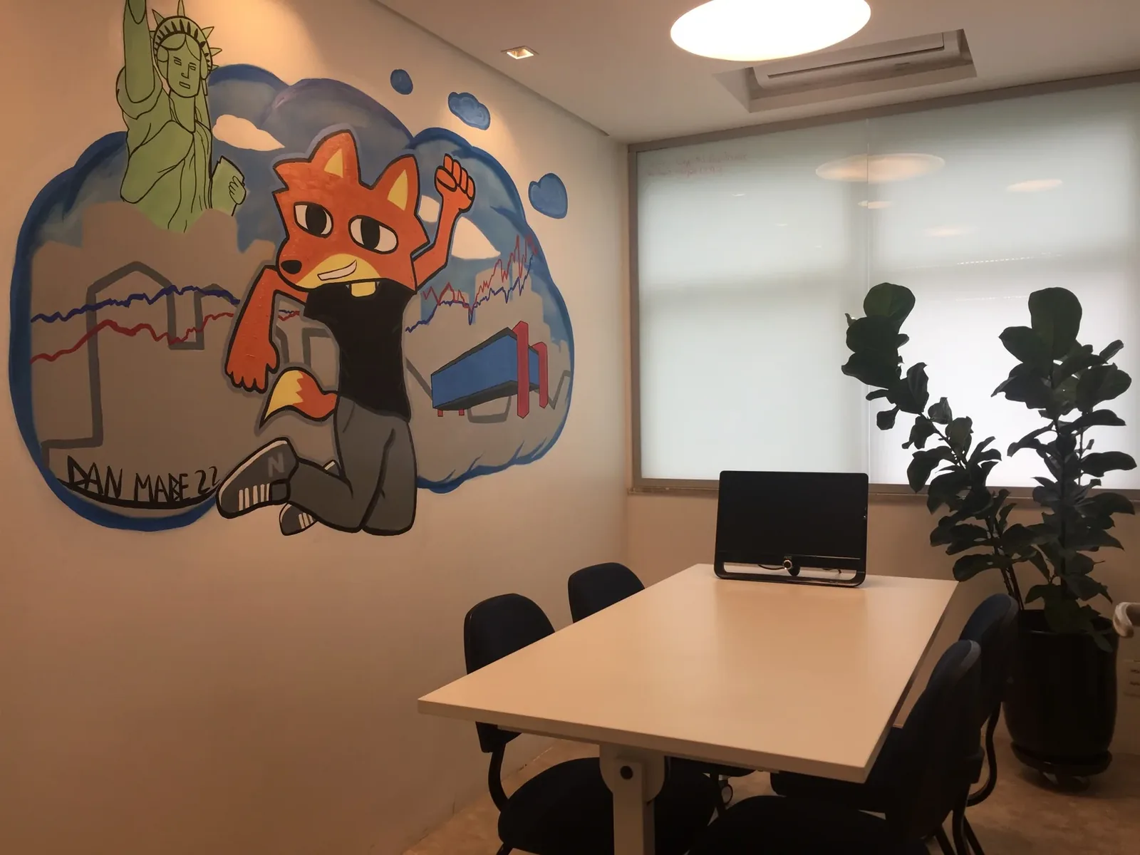 Ambiente de reunião da SP Locus com obra de arte na parede