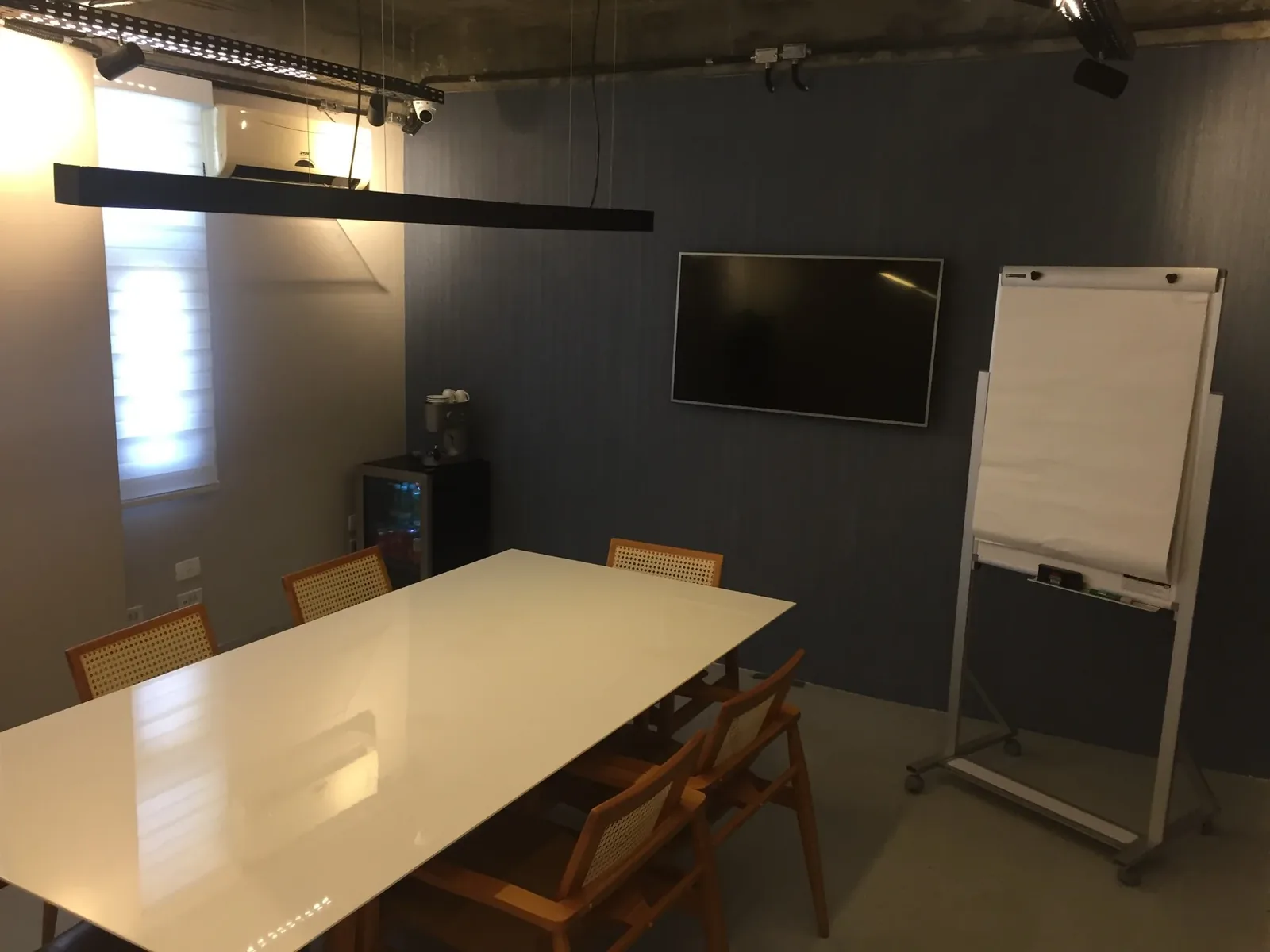 Sala de reunião privativa com mesa de reunião e televisor